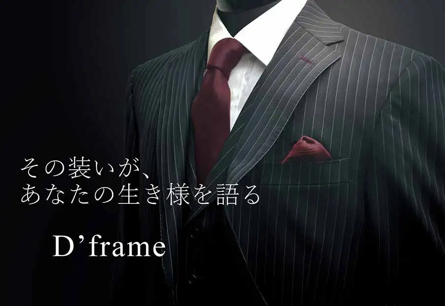 ダークグレーのピンストライプスーツにボルドーのタイとチーフを合わせた上半身のトルソー、静かな陰影のクローズアップ